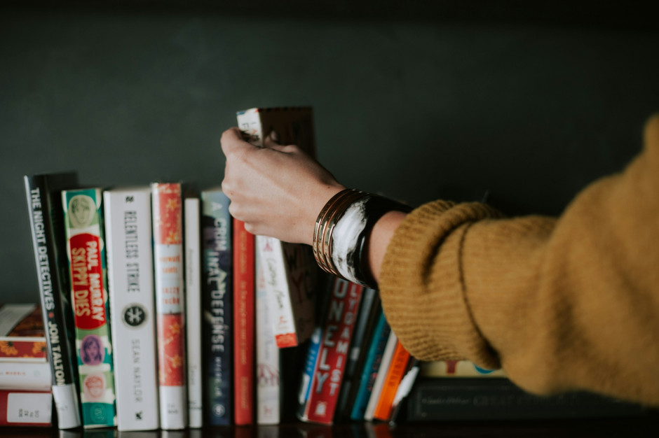 Woman reaching for a book / Unsplash, Christin Hume