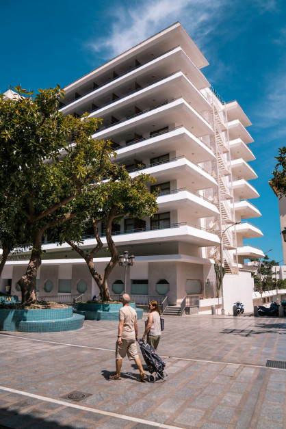 Turistas passando por um prédio de apartamentos em Torremolinos, uma cidade ensolarada na Costa del Sol / Unsplash, Lucia P