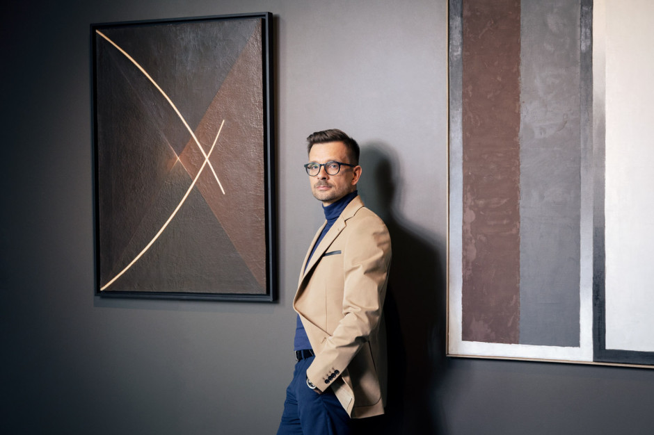 Liwiusz Krawczyk, sanat koleksiyoncusu Stefan Gierowski'nin resimlerinin önünde / Fotoğraf: Marcin Koniak