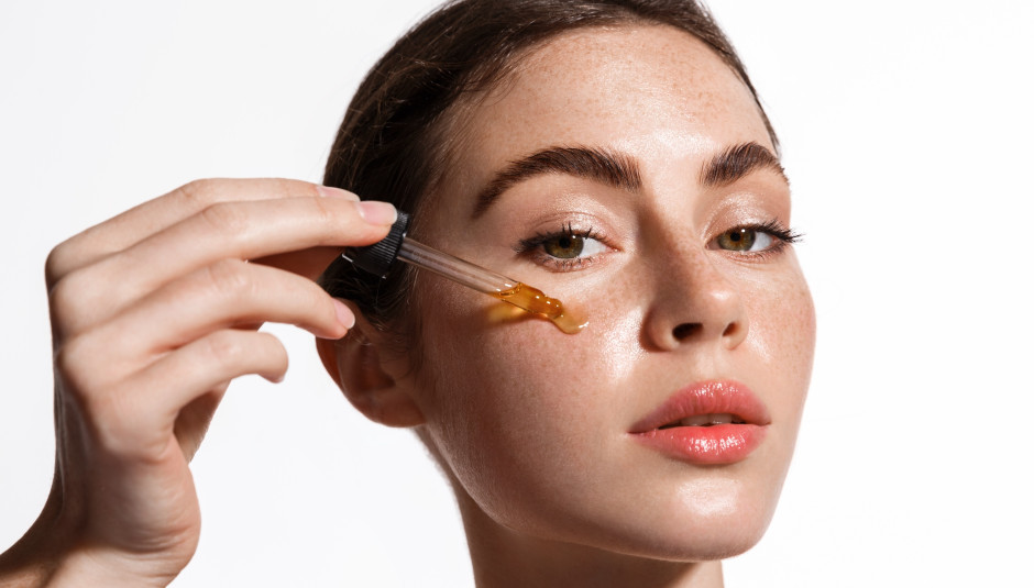 Donna che si applica l'olio sul viso / Shutterstock